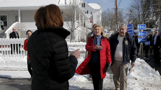 U.S. Democratic presidential candidate Hillary Clinton is greeted by a local resident (L) while canvassing door-to-door to greet voters in a neighborhood in Manchester, New Hampshire February 6, 2016.  REUTERS/Brian Snyder