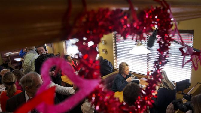 Seen through Valentine's Day heart decorations, Democratic presidential candidate Hillary Clinton campaigns at the Belmont Hall & Restaurant in Manchester, N.H., Saturday Feb. 6, 2016. (AP Photo/Jacquelyn Martin)