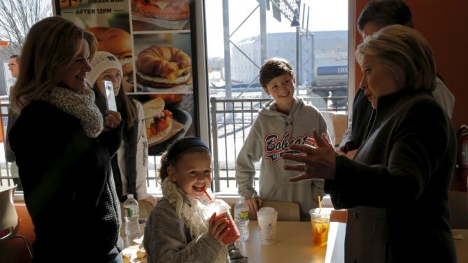 U.S. Democratic presidential candidate Hillary Clinton talks with a family during a stop at a Dunkin' Donuts in Manchester, New Hampshire February 7, 2016.  REUTERS/Brian Snyder