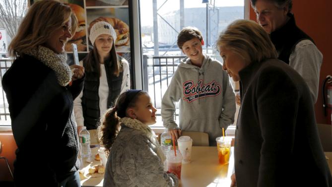 U.S. Democratic presidential candidate Hillary Clinton talks with a family during a stop at a Dunkin' Donuts in Manchester, New Hampshire February 7, 2016.  REUTERS/Brian Snyder