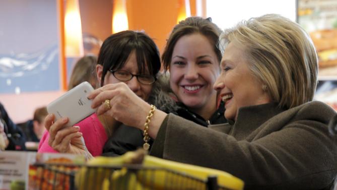 U.S. Democratic presidential candidate Hillary Clinton poses for a selfie during a stop at a Dunkin' Donuts in Manchester, New Hampshire February 7, 2016.  REUTERS/Brian Snyder