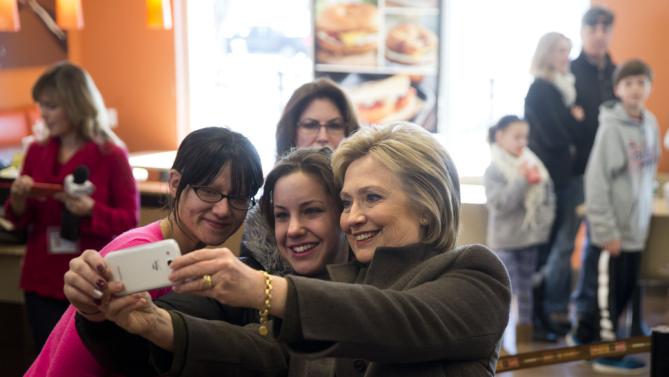 Democratic presidential candidate Hillary Clinton makes a selfie with customers, Sunday, Feb. 7, 2016, at a Dunkin' Donuts in Manchester, N.H. (AP Photo/Matt Rourke)
