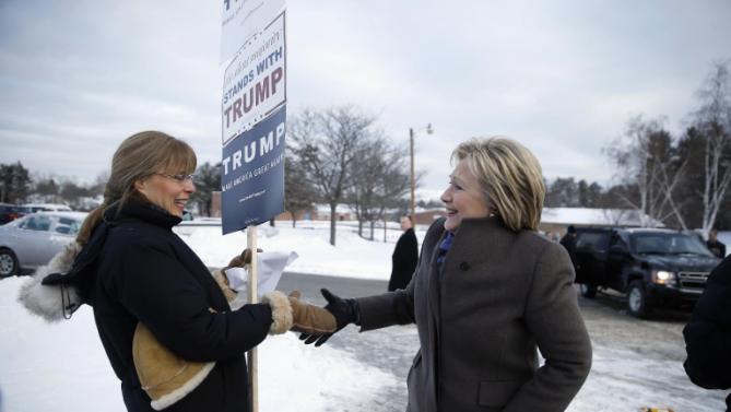 Democratic presidential candidate Hillary Clinton greets a Republican presidential candidate Donald Trump supporter as she campaigns outside a polling place during the first-in-the-nation presidential primary, Tuesday, Feb. 9, 2016, in Nashua, N.H. (AP Photo/Matt Rourke)