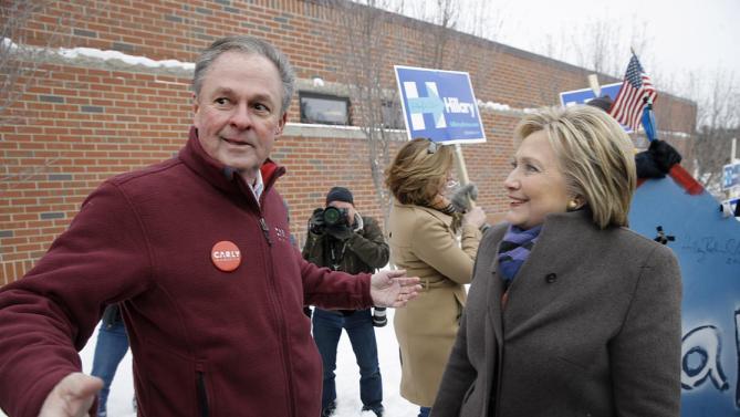 Democratic presidential candidate Hillary Clinton speaks with Frank Fiorina, husband of Republican presidential candidate Carly Fiorina, as they campaign outside a polling place during the first-in-the-nation presidential primary, Tuesday, Feb. 9, 2016, in Derry, N.H. (AP Photo/Matt Rourke)