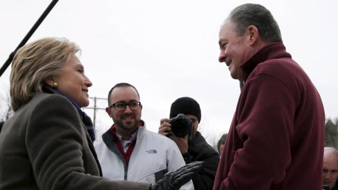 U.S. Democratic presidential candidate Hillary Clinton greets Frank Fiorina, the husband of U.S. Republican presidential candidate Carly Fiorina, outside a polling place in Derry, New Hampshire February 9, 2016, the day of New Hampshire's first-in-the-nation primary.   REUTERS/Brian Snyder