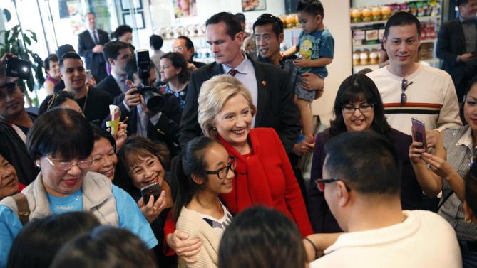 Democratic presidential candidate Hillary Clinton, center, visits Lee's Sandwiches during a campaign stop Sunday, Feb. 14, 2016, in Las Vegas. (AP Photo/John Locher)