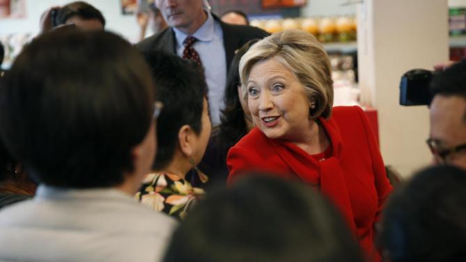 Democratic presidential candidate Hillary Clinton, in red, visits Lee's Sandwiches during a campaign stop Sunday, Feb. 14, 2016, in Las Vegas. (AP Photo/John Locher)