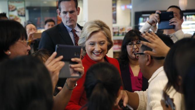 Democratic presidential candidate Hillary Clinton, center in red, meets with people at Lee's Sandwiches during a campaign stop Sunday, Feb. 14, 2016, in Las Vegas. (AP Photo/John Locher)
