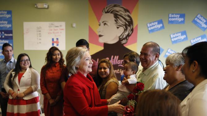 Democratic presidential candidate Hillary Clinton, in red, speaks at an event to meet with young immigrants, or so-called "dreamers," and their families at a campaign office Sunday, Feb. 14, 2016, in Las Vegas. (AP Photo/John Locher)