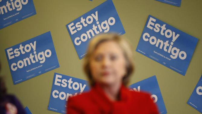 Signs in Spanish that reads, "I am with you," hang on a wall behind Democratic presidential candidate Hillary Clinton as she speaks at an event to meet with young immigrants, or so-called "dreamers," and their families at a campaign office Sunday, Feb. 14, 2016, in Las Vegas.  (AP Photo/John Locher)