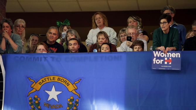 Supporters listen to Democratic presidential candidate Hillary Clinton from behind the Nevada state flag during a rally at Truckee Meadows Community College on Monday, Feb. 15, 2016, in Reno, Nev. (AP Photo/Marcio Jose Sanchez)