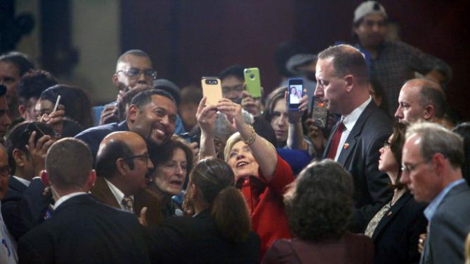 U.S. Democratic presidential candidate Hillary Clinton takes a "selfie" with supporters at a late night rally in Houston after winning the Iowa Democratic caucus, February 20, 2016. Picture taken late February 20, 2016. REUTERS/Daniel Kramer