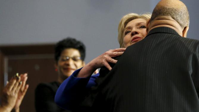 U.S. Democratic presidential candidate Hillary Clinton (2nd R) gets a hug as she takes the stage for a town hall meeting at Central Baptist Church in Columbia, South Carolina February 23, 2016. REUTERS/Jonathan Ernst