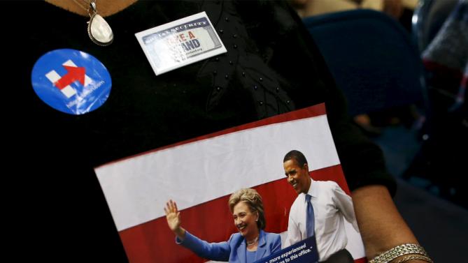 A supporter hold a photo of U.S. Democratic presidential candidate Hillary Clinton with U.S. President Barack Obama before a Clinton town hall meeting at the Garrick-Boykin Human Development Center at Morris College in Sumter, South Carolina, February 24, 2016. REUTERS/Randall Hill EDITORIAL USE ONLY. NO RESALES. NO ARCHIVE
