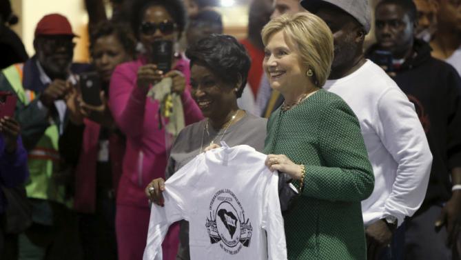 U.S. Democratic presidential candidate Hillary Clinton is presented with a t-shirt greets supporters at the International Longshoremen's Association Local 1422 in Charleston, South Carolina February 24, 2016. REUTERS/Jonathan Ernst