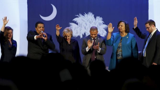 U.S. Democratic presidential candidate Hillary Clinton (3rd L) holds her hand up in prayer with local officials after a town hall meeting for supporters at Royal Baptist Church Family Life Center in North Charleston, South Carolina February 25, 2016. REUTERS/Jonathan Ernst