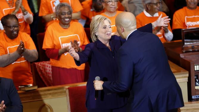 Democratic presidential candidate Hillary Clinton hugs Sen. Corey Booker, D-N.J., as she arrives to speak at a campaign event at the Cumberland United Methodist Church in Florence, S.C., Thursday, Feb. 25, 2016. (AP Photo/Gerald Herbert)