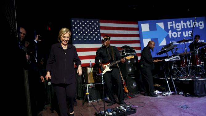 Democratic U.S. presidential candidate Hillary Clinton joins singer Charlie Wilson (not pictured) and his band onstage during a get-out-the-vote concert in support of her at the Music Farm in Charleston, South Carolina February 25, 2016. REUTERS/Jonathan Ernst