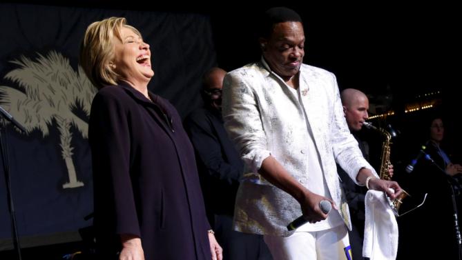 Democratic U.S. presidential candidate Hillary Clinton (L) joins singer Charlie Wilson on stage during a get-out-the-vote concert in support of her at the Music Farm in Charleston, South Carolina February 25, 2016. REUTERS/Jonathan Ernst