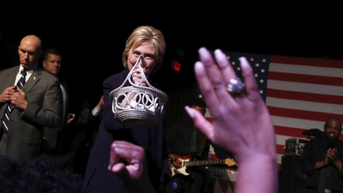 Democratic U.S. presidential candidate Hillary Clinton receives a traditional Gullah woven grass basket from a supporter as she joins singer Charlie Wilson (not pictured) on stage during a get-out-the-vote concert in support of her at the Music Farm in Charleston, South Carolina February 25, 2016. REUTERS/Jonathan Ernst