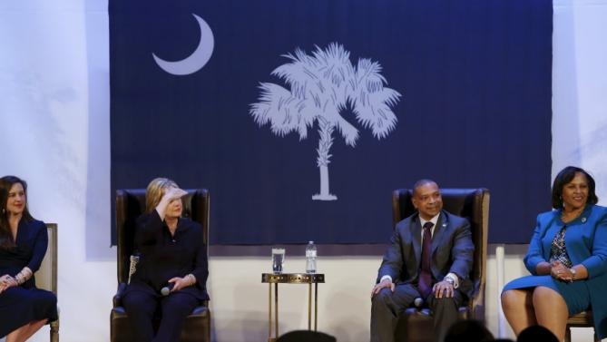 U.S. Democratic presidential candidate Hillary Clinton (2nd L), onstage with local officials, looks into the audience to be able to see a person asking a question during a town hall meeting with supporters at Royal Baptist Church Family Life Center in North Charleston, South Carolina February 25, 2016. REUTERS/Jonathan Ernst