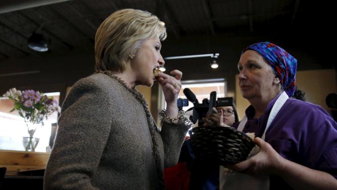 U.S. Democratic Presidential candidate Hillary Clinton tries a sample of coconut pound cake at Saffron Cafe and Bakery as she arrives to greet voters at the cafe in Charleston, South Carolina, February 26, 2016. REUTERS/Jonathan Ernst