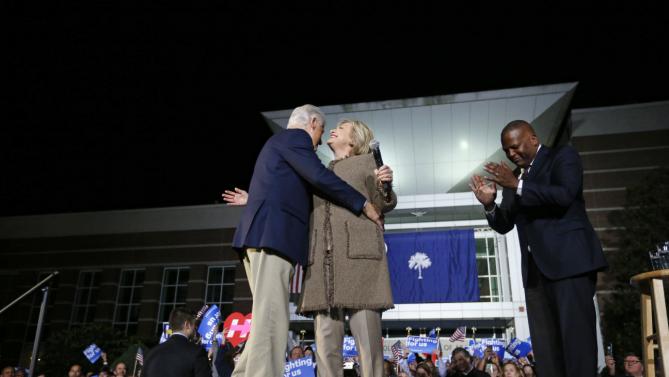 Democratic presidential candidate Hillary Clinton and her husband, former President Bill Clinton, hug as they arrive to speak at a "Get Out The Vote Rally" in Columbia, S.C., Friday, Feb. 26, 2016. Right is Columbia Mayor Stephen K. Benjamin. (AP Photo/Gerald Herbert)