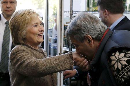 Saffron Cafe and Bakery owner Ali Rahnamoon (R) kisses the hand of U.S. Democratic Presidential candidate Hillary Clinton as she arrives to greet voters at his cafe in Charleston, South Carolina, February 26, 2016. REUTERS/Jonathan Ernst