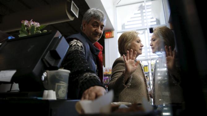 U.S. Democratic presidential candidate Hillary Clinton politely declines to eat more cake samples, after having tried the coconut pound cake and purchasing items to go from Saffron Cafe and Bakery owner Ali Rahnamoon as she greets people at his cafe in Charleston, South Carolina February 26, 2016. REUTERS/Jonathan Ernst      TPX IMAGES OF THE DAY