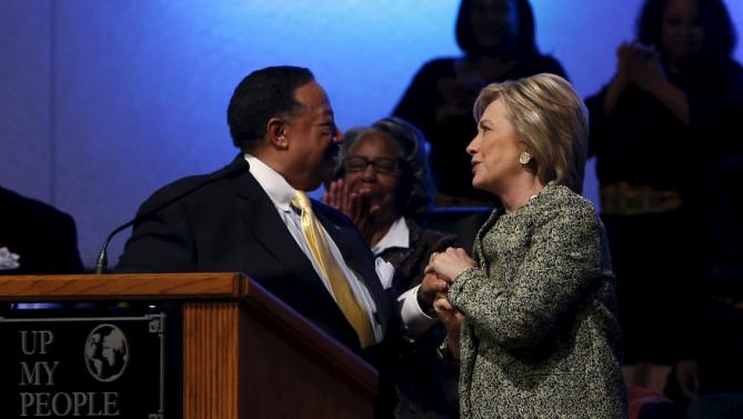 U.S. Democratic presidential candidate Hillary Clinton clasps hands with pastor Bill Adkins (L) after speaking during a church service at the Greater Imani Cathedral of Faith in Memphis, Tennessee, February 28, 2016. REUTERS/Jonathan Ernst