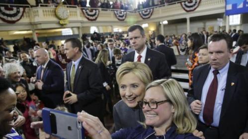 Democratic presidential candidate Hillary Clinton is surrounded by security as she poses for a photo with a supporter at a campaign event at the Old South Meeting House, Monday, Feb. 29, 2016, in Boston. (AP Photo/Elise Amendola)