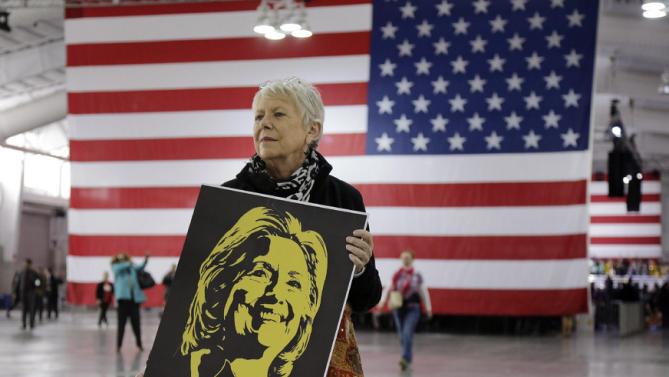 Campaign volunteer Leila Walsh of Jersey City, N.J., stands near an entrance to the Jacob Javits Center to greet supporters as they arrive before the start of a rally for Democratic presidential candidate Hillary Clinton, Wednesday, March 2, 2016, in New York. (AP Photo/Julie Jacobson)