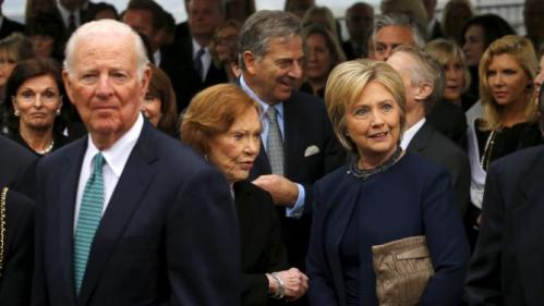 Former secretary of state James Baker (L) waits in a receiving line with former first lady Rosalynn Carter (C) and former first lady Hillary Clinton (R) as they pay their respects during the funeral for former first lady Nancy Reagan at the Ronald Reagan Presidential Library in Simi Valley, California March 11, 2016.  REUTERS/Mike Blake