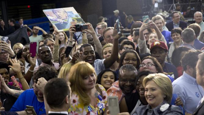 A person on the audience hold up an image of Republican presidential candidate Donald Trump as Democratic presidential candidate Hillary Clinton greets supporters and takes photos during a campaign event at the Grady Cole Center in Charlotte, N.C., Monday, March 14, 2016. (AP Photo/Carolyn Kaster)