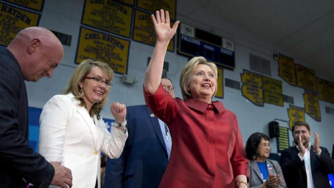 Democratic presidential candidate Hillary Clinton waves as she arrives at a campaign event at Carl Hayden Community High School in Phoenix, Monday, March 21, 2016. With Clinton on stage from left are former Rep. Gabrielle Giffords, and her husband Mark Kelly, Governor of the Gila River Indian Community Stephen Roe Lewis, labor leader Dolores Huerta, and Rep. Ruben Gallego, D-Ariz.(AP Photo/Carolyn Kaster)