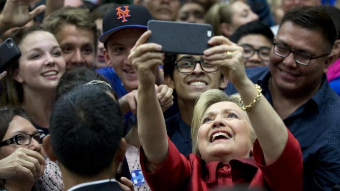 Democratic presidential candidate Hillary Clinton takes photos with people in the audience after speaking during a campaign event at Carl Hayden Community High School in Phoenix, Monday, March 21, 2016. (AP Photo/Carolyn Kaster)