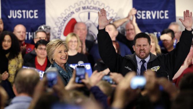 Democratic presidential candidate Hillary Clinton, left, is introduced by Boeing Machinists' union local president Jon Holden at a campaign event at the Boeing Machinists' union hall Tuesday, March 22, 2016, in Everett, Wash. (AP Photo/Elaine Thompson)