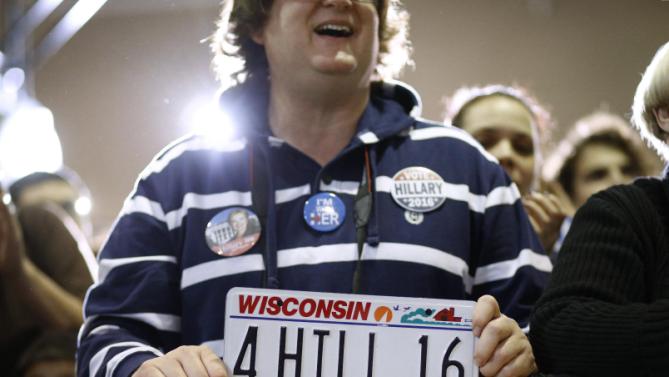A supporter holds a license plate as he listens to Democratic presidential candidate Hillary Clinton speak at the Mary Ryan Boys and Girls Club in Milwaukee, Wis., Monday, March 28, 2016. (AP Photo/Patrick Semansky)