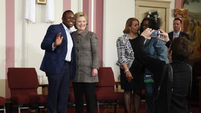 Patrice Achu, left, a naturalized U.S. citizen who grew up in Cameroon and said he will cast his first vote as a citizen for Clinton, poses for a photo with Democratic presidential candidate Hillary Clinton after a forum on gun violence, Tuesday, March 29, 2016, at the Tabernacle Community Baptist Church in Milwaukee. (AP Photo/Patrick Semansky)