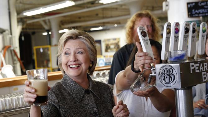 Democratic presidential candidate Hillary Clinton hoists a beer during a tour of at Pearl Street Brewery in La Crosse, Wis., Tuesday, March 29, 2016. (AP Photo/Patrick Semansky)