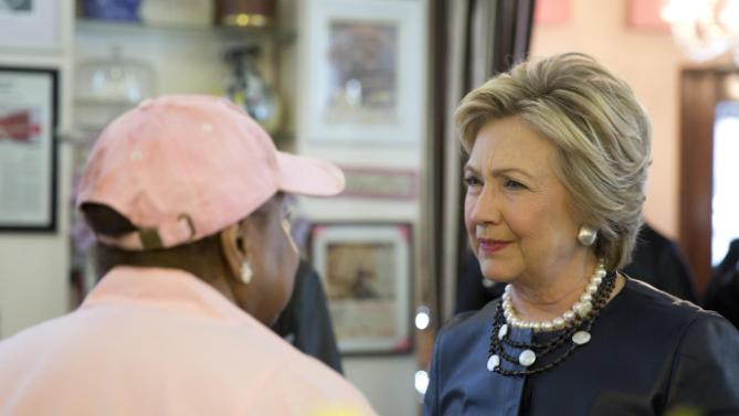 Democratic presidential candidate Hillary Clinton, right, meets a member of the community, during a campaign stop at the Make My Cake bakery, Wednesday, March 30, 2016, in the Harlem neighborhood of New York. (AP Photo/Mary Altaffer)