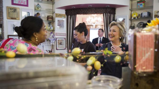 Democratic presidential candidate Hillary Clinton, right, meets a member of the community, left, at Make My Cake Bakery, Wednesday, March 30, 2016, in the Harlem neighborhood of New York. (AP Photo/Mary Altaffer)
