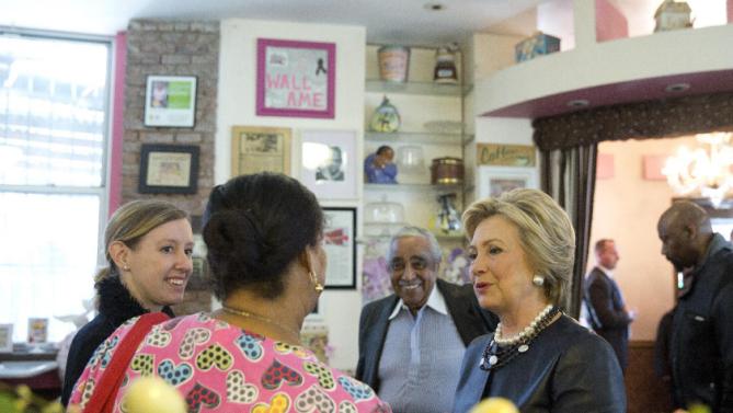 Rep, Charles Rangel, background, D-N.Y. watches as Democratic presidential candidate Hillary Clinton, right, meets a member of the community, second from left, at Make My Cake Bakery, Wednesday, March 30, 2016, in the Harlem neighborhood of New York. (AP Photo/Mary Altaffer)