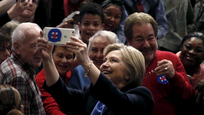 U.S. Democratic presidential candidate Hillary Clinton takes a selfie photograph with supporters after speaking at a campaign rally at State University of New York (SUNY) at Purchase in Westchester County, New York, March 31, 2016. REUTERS/Mike Segar